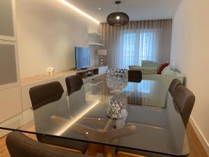 a glass dining room table and chairs in a living room at Oktheway Ron Fraga Place in A Coruña