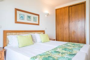 a bedroom with a bed and a wooden cabinet at Clube Porto Mos - Sunplace Hotels & Beach Resort in Lagos