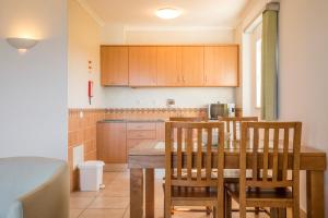 a kitchen with a wooden table and chairs in it at Clube Porto Mos - Sunplace Hotels & Beach Resort in Lagos