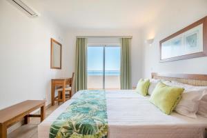 a bedroom with a bed with a view of the ocean at Clube Porto Mos - Sunplace Hotels & Beach Resort in Lagos +134 photos