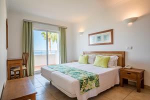 a bedroom with a bed and a large window at Clube Porto Mos - Sunplace Hotels & Beach Resort in Lagos