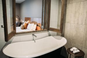 y baño con lavabo blanco y espejo. en King and Queen Hotel Suites, en New Plymouth