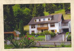 ein weißes Haus mit einem Zaun und einem Hof in der Unterkunft Ferienwohnung, Monteurwohnung Steger in Frammersbach