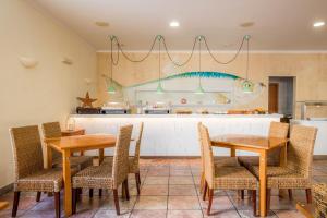 a kitchen with two tables and chairs and a counter at Clube Porto Mos - Sunplace Hotels & Beach Resort in Lagos