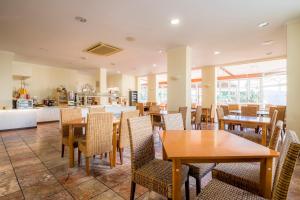 a restaurant with tables and chairs and a kitchen at Clube Porto Mos - Sunplace Hotels & Beach Resort in Lagos