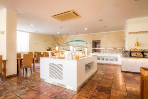 a large kitchen and dining room with tables and chairs at Clube Porto Mos - Sunplace Hotels & Beach Resort in Lagos