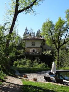 Hostellerie Restaurant Les Gorges de l'Aveyron في Bruniquel: منزل أمامه مسبح وكراسي