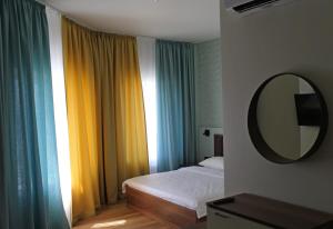um quarto com uma cama, um espelho e cortinas em EP Boutique Hotel em Vladivostok
