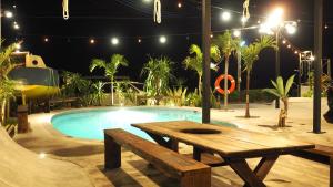 a picnic table next to a swimming pool at night at MARINX CLASSIC HARBORVIEW PENSION in Yaese