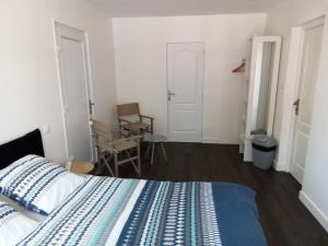 ein Schlafzimmer mit einem Bett, einem Tisch und einem Stuhl in der Unterkunft Le cheminblanc suite parentale in Saint-Sornin