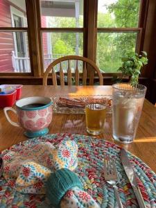 a wooden table with a plate and a fork and knife at Plain & Fancy Bed & Breakfast in Ironton