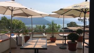 a patio with tables and umbrellas on a balcony at Casa Cielo in Valle de Bravo
