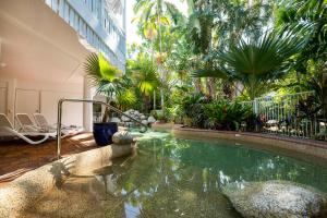 a pool in the middle of a building with trees at The White House Port Douglas in Port Douglas