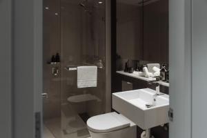 a bathroom with a sink and a toilet and a shower at SKYE Suites Green Square in Sydney
