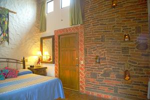 a bedroom with a bed and a brick wall at Quinta Don Jose Boutique Hotel in Guadalajara
