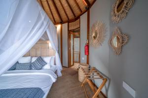 a bedroom with a bed and a mirror on the wall at Ora Resort Avia Blue Lagoon in Nusa Lembongan