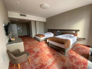 um quarto de hotel com duas camas e uma cadeira em HUNNU HOTEL em Ulan-Ude