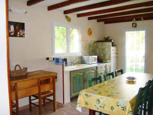 a kitchen with a table and a sink and a table and chairs at Chambres d'Hôtes de Curnier in Bédoin