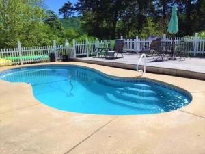 una pequeña piscina en un patio con una valla blanca en Plain & Fancy Bed & Breakfast, en Ironton