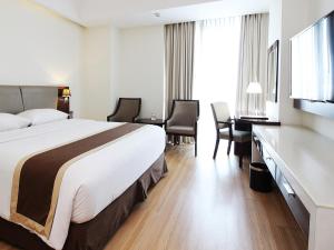 a hotel room with a bed and a desk at Java Palace Hotel in Cikarang