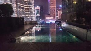 a pool of water in the middle of a city at night at Avenue K in Kuala Lumpur