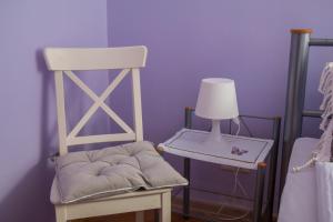 una silla blanca con una lámpara junto a la cama en Rabianska Suite, en Toruń