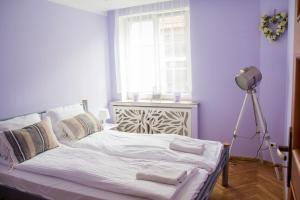 Bett in einem Zimmer mit einer Lampe und einem Fenster in der Unterkunft Rabianska Suite in Toruń