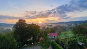 an aerial view of a house in a field with the sunset at Noclegi Tyczyn in Tyczyn