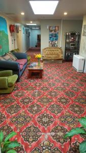 a living room with couches and a rug at Ariki Backpackers in New Plymouth