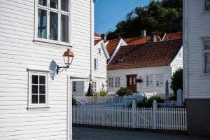 a white house with a white picket fence at Idylliske Skudeneshavn in Skudeneshavn