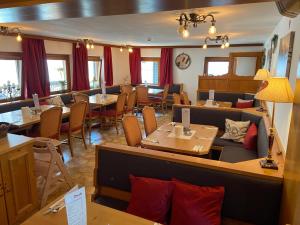 a restaurant with tables and chairs in a room at Pension Eder - Joker card included in summer in Saalbach-Hinterglemm