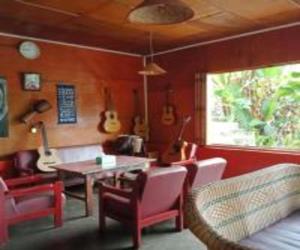 een kamer met een tafel en stoelen en gitaren aan de muur bij Laster Jony's in Tuk Tuk