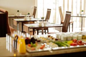 ein Restaurant mit Tischen und Stühlen mit Essen darauf in der Unterkunft Hotel Garni Toscanina - Adults Only in Bad Radkersburg