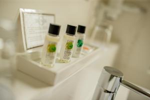 tre bottiglie di crema idratante sedute su una mensola in bagno di Hotel Garni Toscanina - Adults Only a Bad Radkersburg