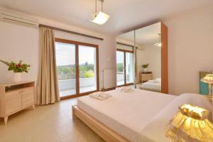 1 dormitorio con cama y ventana grande en Sunlight Eros Villa, en Áfra