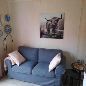 eine blaue Couch in einem Wohnzimmer mit einem Bild eines Stiers in der Unterkunft Studio Bluuven in Scharendijke