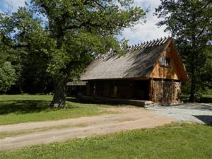 a wooden barn with a tree in a field at Laugu Holiday Resort in Laugu