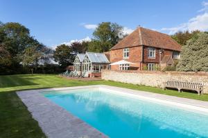 a house with a swimming pool in front of a house at Dormestone Farm by Bloom Stays in Ashford