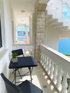 a balcony with a table and chairs and the ocean at Villa Maluma in Rogoznica
