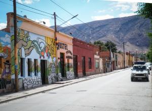 a street in a town with buildings with graffiti at Tierra Andina Hostel in Tilcara