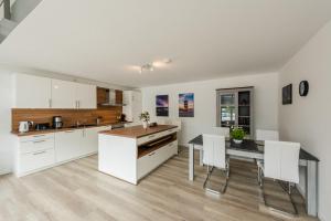 a kitchen with white cabinets and a table and chairs at WH Boardinghouse in Papenburg