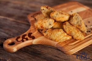 a wooden plate with some fried food on it at GG Group Hotel in Almaty