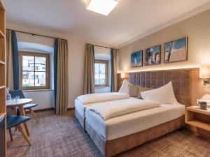 キルヒベルク・イン・チロルにあるAlpen Glück Hotel Unterm Rain garniのベッドとテーブルが備わるホテルルームです。