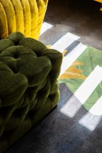 a green couch in a room with a rug at Hotel Aalders in Amsterdam