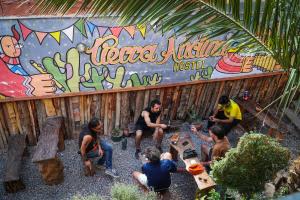 un grupo de personas sentadas frente a un mural en Tierra Andina Hostel en Tilcara