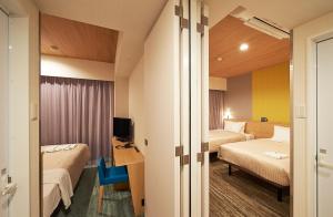 Postel nebo postele na pokoji v ubytování Sotetsu Fresa Inn Tokyo Tamachi