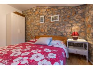 um quarto com uma cama e uma parede de pedra em Modern Holiday Home in Polje with Air Conditioning em Polje