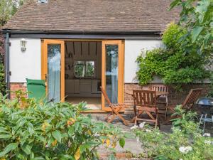 a cottage with a door and a table and chairs at The Figgy by Bloom Stays in Ashford