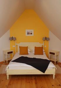 1 dormitorio con 1 cama grande y pared amarilla en Apartament Kaszubska Sielanka, en Kartuzy