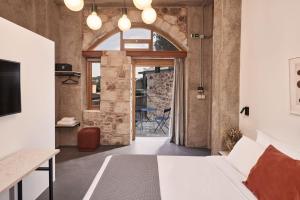 Asomaton في أثينا: غرفة معيشة مفتوحة مع جدار حجري